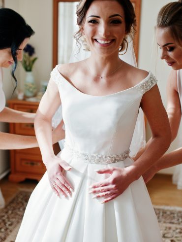 Sustainably conscious bride being fitted in a designer sample dress